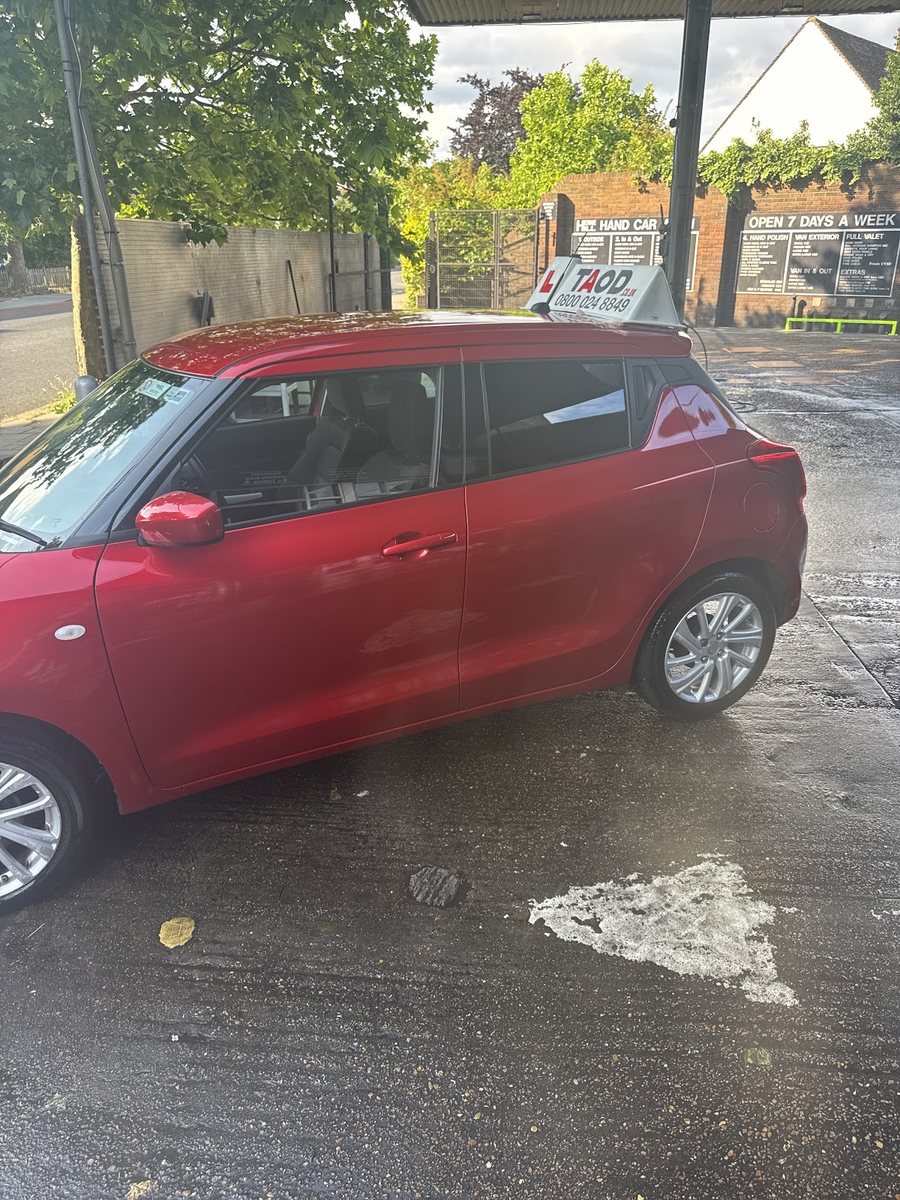A freshly washed red hatchback under the canopy at Herne Hill Hand Car Wash