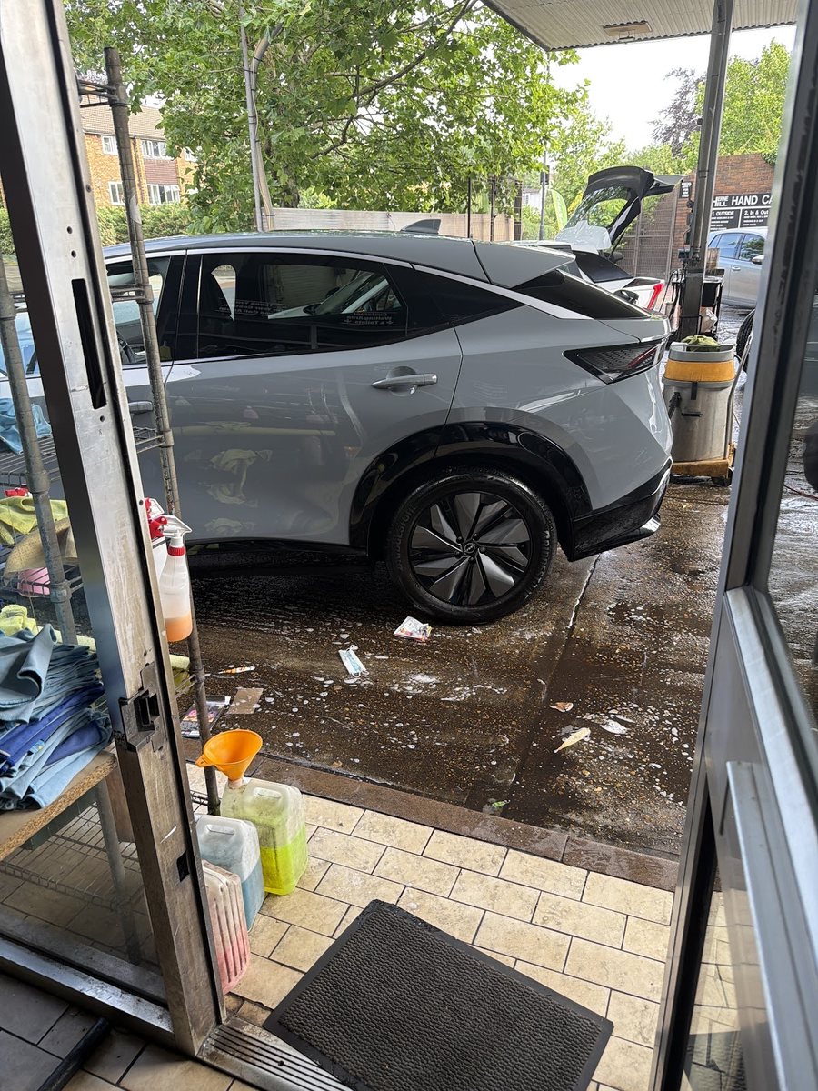 A car being washed by hand on the forecourt