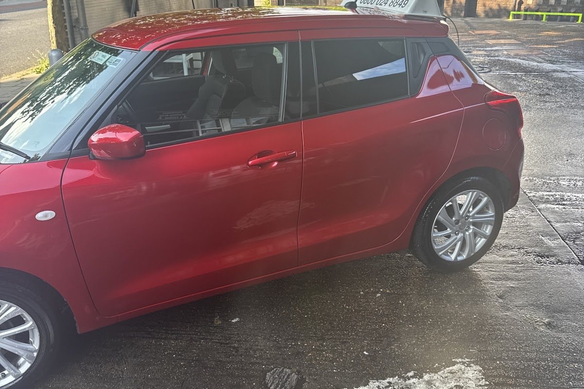 A freshly washed red hatchback under the canopy at Herne Hill Hand Car Wash